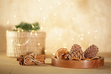 Chrismas mood still life: cinnamon, anise, pine cones and gift box in golden christmas lights