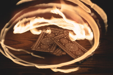 Tarot cards deck and fire flame around close up.
