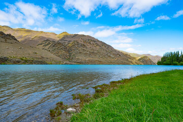 River banks flowing water and hills on other side of scenic Clutha River