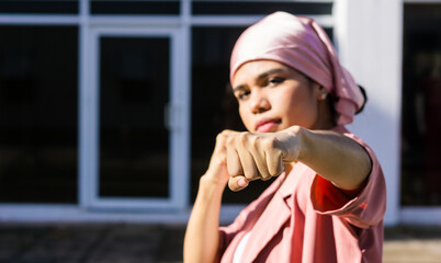 Hispanic young woman with pink headscarf ready to fight and raises awareness against women's...