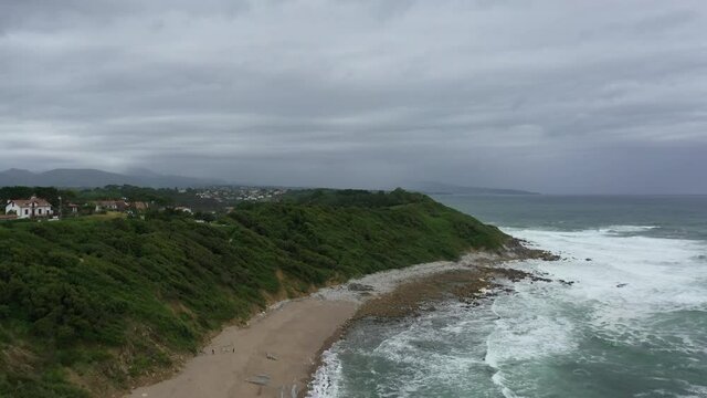 aerial shot of ocean green coast in the south west of France during a cloudy day with wind.