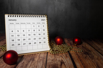white calendar showing the month of January 2021 on wood with Christmas decorations
