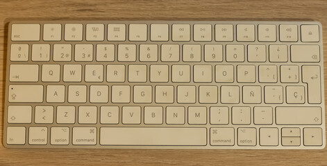 En la foto, aparece un teclado blanco elegante minimalista. En una mesa de madera limpia y...