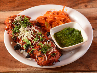 Chicken angara momo with mint chutney served over a rustic wooden background, selective focus