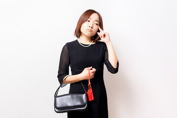 考えるジェスチャーをする喪服を着た女性