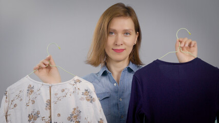 Portrait of an attractive woman. The girl is at home, and is engaged in clothing and fashion