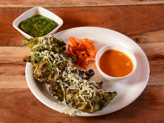 Chicken hariyali momo with sauce and mint chutney served over a rustic wooden background, selective focus
