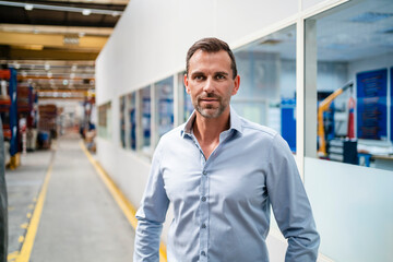 Confident male entrepreneur standing in industry