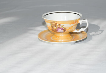 beautiful cup stands on a white table the sun is shining