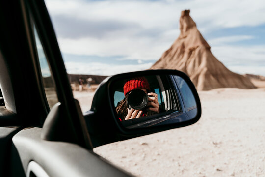 Side-view mirror reflection of female tourist using camera&Ocirc;&oslash;&Omega;