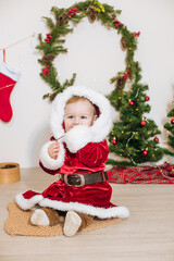 Little cute boy dressed as Santa near little Christmas trees. Christmas mood