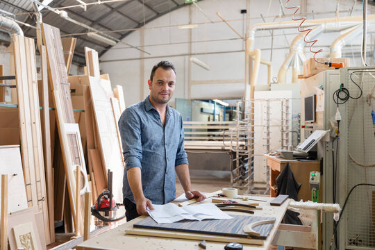 Project manager smiling while standing at factory