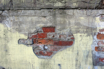 A piece of brickwork, with collapsed concrete  broken wall