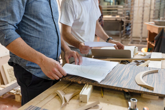 Employee checking design of furniture while standing at factory