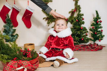 Obraz na płótnie Canvas Little cute boy dressed as Santa near little Christmas trees. Christmas mood