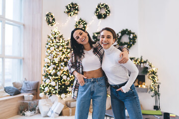 Cheerful siblings hugging and smiling while having Christmas fun