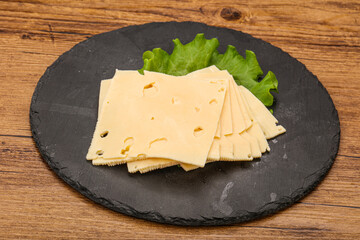 Sliced yellow cheese over board