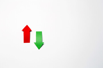 Two up-down arrows, cutted from the red and green paper on the white plain paper background showing growth and drops of stock market or up-down direction