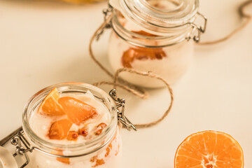 Orange and sea-buckthorn homemade yoghurt in glass jars on white background. Colorful food. Copy space