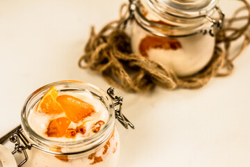 Orange and sea-buckthorn homemade yoghurt in glass jars on white background. Colorful food. Copy space