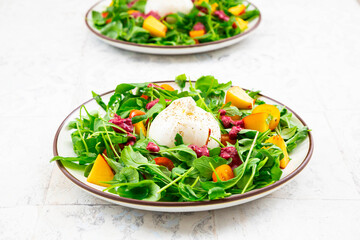 Two plates of vegetarian salad with fruits, vegetables and burrata cheese