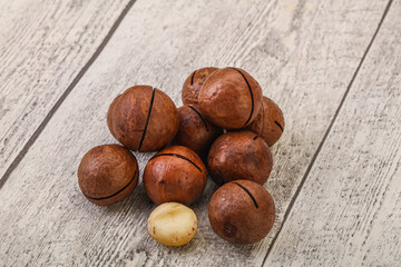 Brown macadamia nut heap over background