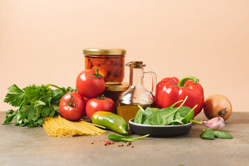 Set of products for cooking traditional Italian meal. Vegetables, herbs, olive oil, spaghetti, sun dried tomato on beige background