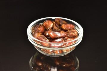 Sweet dried dates, close-up, on a black background.