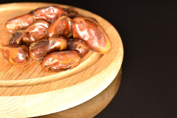 Sweet dried dates, close-up, on a black background.