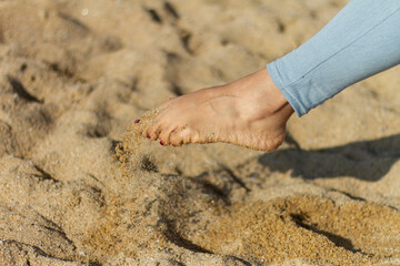 Girl peep playing with sand with painted nails