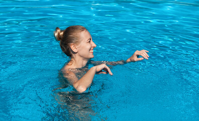 Beautiful young nude woman in swimming pool
