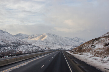 Highway in the middle of the mountains in a snowy winter. A beautiful asphalt road among the snow-covered mountains. Oregon, USA