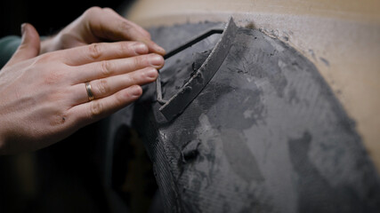 The man works in a tuning studio. Car tuning. The building of the car's arch layout.