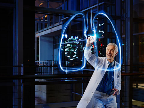 Smiling male pulmonologist examining lung in laboratory at hospital