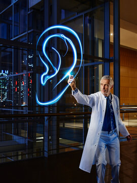 Male otolaryngologist analyzing ear in laboratory at hospital