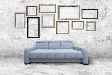 Many empty photo frames on a concrete wall in a light room with a sofa