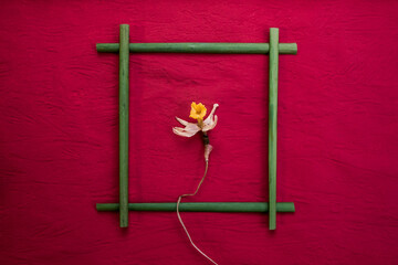 frame made of stems of flowers, and in it a dry narcissus flower