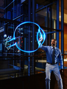 Mature male ophthalmologist light painting eyeball in laboratory at hospital