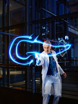 Mature male internist light painting pancreas in laboratory at hospital