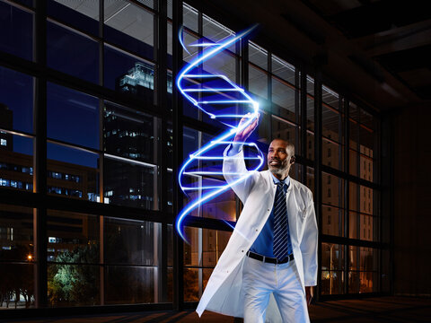 Mature male doctor light painting DNA in laboratory at hospital - Powered by Adobe
