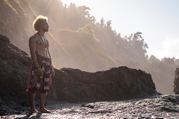Shirtless young man standing on rock formation during sunny day
