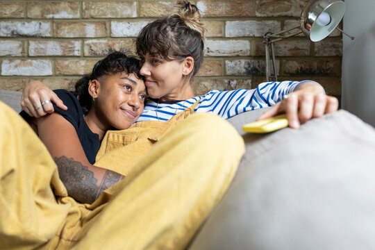 Young lesbian couple relaxing on sofa at home
