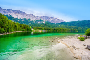 Naklejka na ściany i meble Eibsee lake with Zugspitze mountain in the background. Beautiful landscape scenery with paradise beach and clear blue water in German Alps - Garmisch Partenkirchen, Grainau - Bavaria, Germany, Europe.