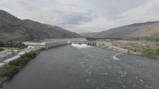 Scenic View Of Water Flowing In Slow Motion At The Rocky Reach Dam In Columbia River Near Wenatchee In Washington - aerial drone, pullback shot