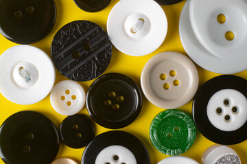 Buttons of different diameters and different colors on a yellow background.
