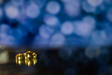 Golden wedding rings on sparkle bokeh background. Selective focus with copy space for text. Wedding...