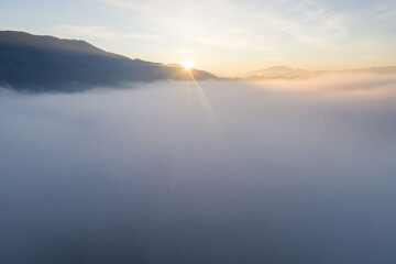 Flying through the clouds at dawn above the jumping lake in Rieti