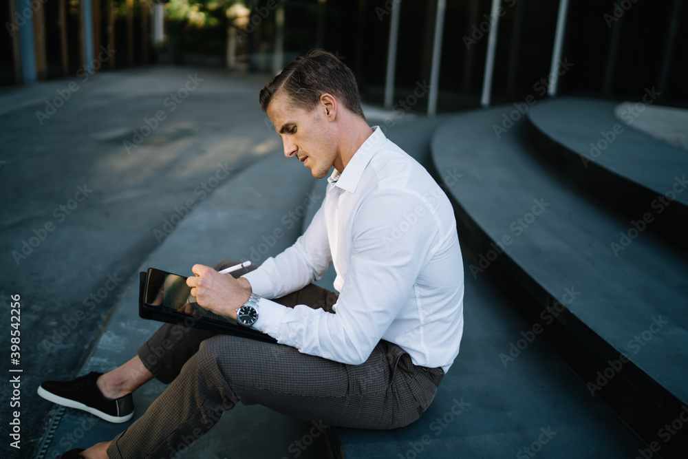 Poster side view of professional entrepreneur creating graphic design via application on touch pad using st