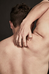 Mann mit Juckreiz kratzt sich am R&uuml;cken 