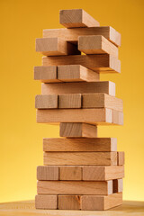 The concept of entrepreneurial risk. Wooden blocks on a yellow background.